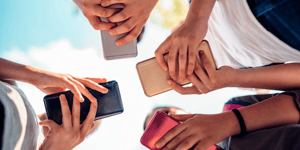 People gathered around looking at smartphones